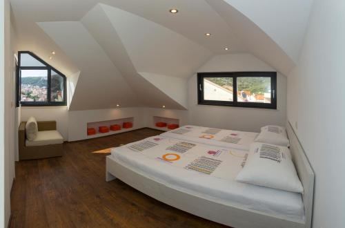 a bedroom with a large white bed and two windows at Villa Marijeta Hvar in Hvar