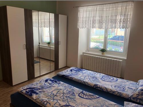 um quarto com 2 camas e uma grande janela em Apartma Mahnič em Postojna