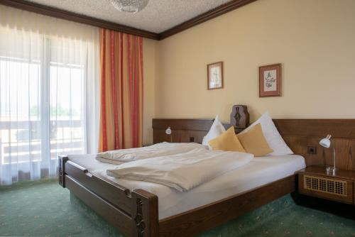 una camera da letto con un letto e una grande finestra di Hotel Kanz a Egg am Faaker See