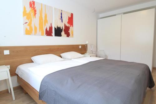 a bedroom with a bed and a painting on the wall at Drance 16 Apartments in Selce