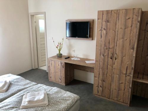 a bedroom with a wooden desk with a tv on the wall at Chata pod Ostrým vrchom in Soblahov
