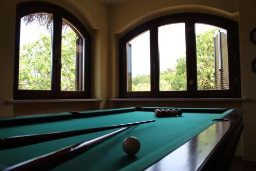 a pool table in a room with three windows at Villa Sarno in Montesilvano