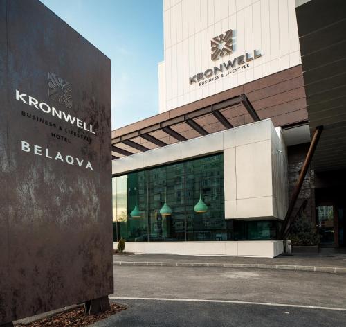 a building with a sign in front of it at Kronwell Brasov Hotel in Braşov