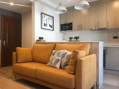 an orange couch with pillows on it in a kitchen at Apartament Neret II in Sort