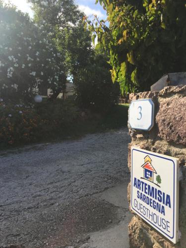 a sign on a stone wall next to a road at Artemisia Sardegna in Tergu