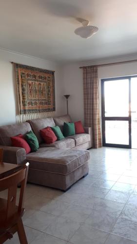 a living room with a couch with colorful pillows at Manta Rota Mar Apartamento in Manta Rota