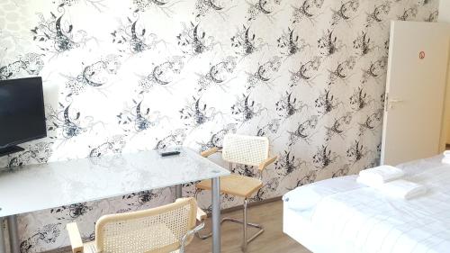 a room with a desk and chairs and a wall at Aparthotel B & L in Bremen