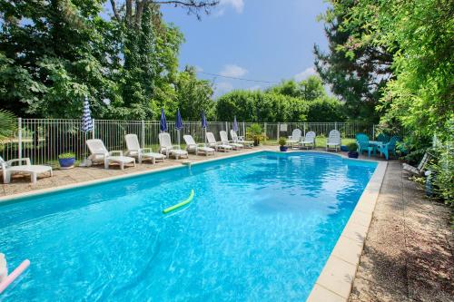 - une piscine avec des chaises et une nouille dans l'eau dans l'établissement Le Manoir Lacustre, à Queyrac