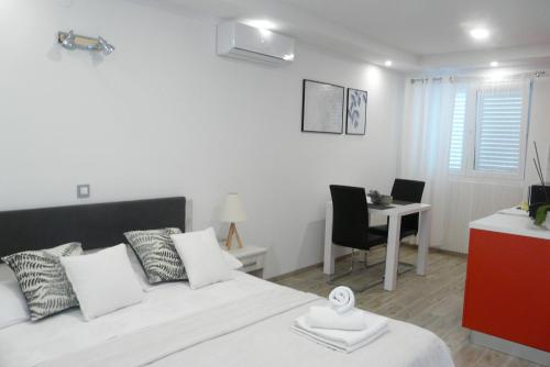 a bedroom with a bed and a table and a desk at Apartments Sabioncello in Orebić