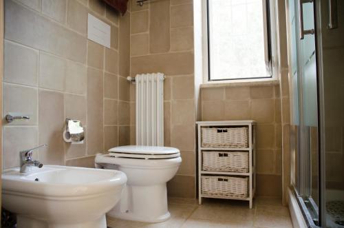 a bathroom with a toilet and a sink and a window at Trullo Grazioso Luxury in Ceglie Messapica
