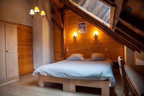 a bedroom with a bed with a wooden wall at La Ferme De Noémie in Mercury