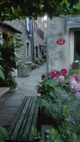 an alley with flowers and a sign on a building at Rooms Svalina in Grožnjan