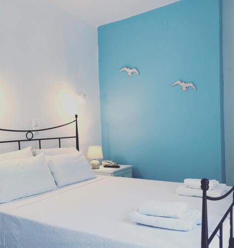 a bedroom with a bed with white sheets and two towels at Danaides Studios in Batsi