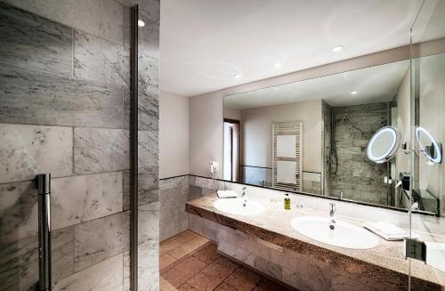 a bathroom with two sinks and a large mirror at Hotel Kronelamm im Schwarzwald in Bad Teinach-Zavelstein