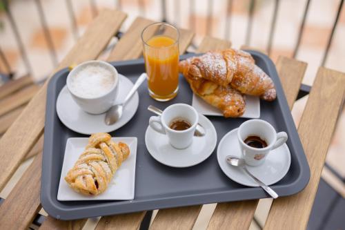 a tray of food with cups of coffee and pastries at B&B La perla dei casali in Giffoni Sei Casali