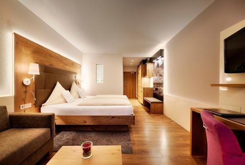 a hotel room with a bed and a couch at Hotel Kronelamm im Schwarzwald in Bad Teinach-Zavelstein