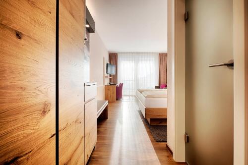 a room with a bedroom with a bed and a closet at Hotel Kronelamm im Schwarzwald in Bad Teinach-Zavelstein