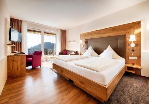 a hotel room with a large bed and a television at Hotel Kronelamm im Schwarzwald in Bad Teinach-Zavelstein
