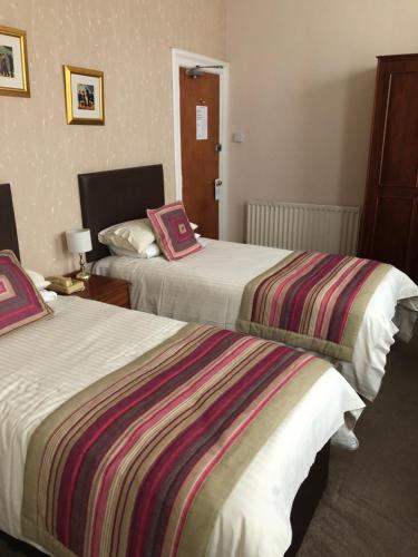 ein Hotelzimmer mit 2 Betten und bunten Decken in der Unterkunft The Hydro Hotel in Douglas