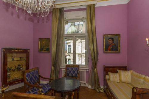 a living room with purple walls and a table and a window at Filip’s Palace Luxurious Apartment in Ljubljana
