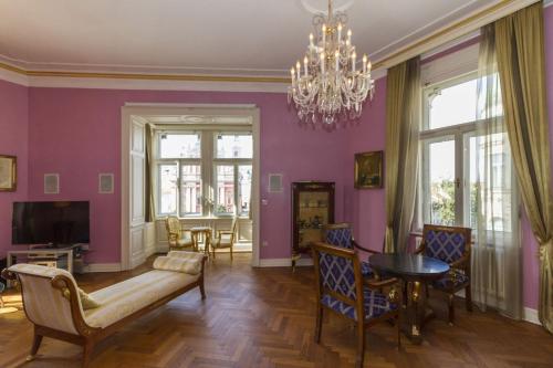 a living room with purple walls and a chandelier at Filip’s Palace Luxurious Apartment in Ljubljana