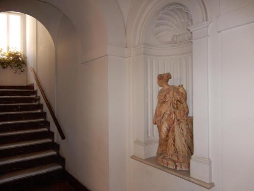 a statue of a woman sitting next to a staircase at Luciano And Son in Campobasso