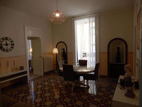 a living room with a table and chairs and a clock at Luciano And Son in Campobasso