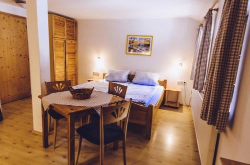 a bedroom with a bed and a table and a dining room at Haflingerhof - Oberjoch in Bad Hindelang