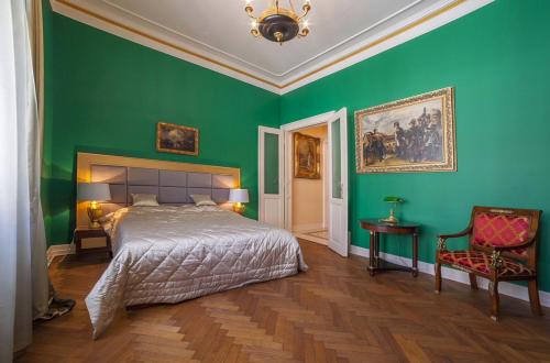 a bedroom with green walls and a bed and a chair at Filip’s Palace Luxurious Apartment in Ljubljana