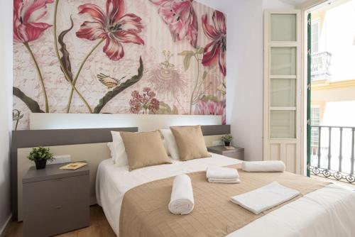 马拉加Apartamento Centro Histórico II的一间卧室配有一张带花卉壁纸的大床