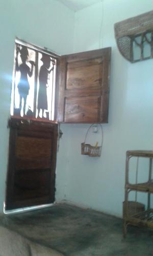 a room with a wooden cabinet and a window at Saldomar B&Biosphere in Bubaque