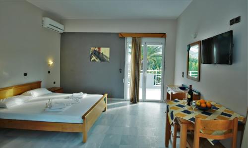 um quarto com uma cama e uma sala de jantar com uma mesa em Athena Hotel em Georgioupolis