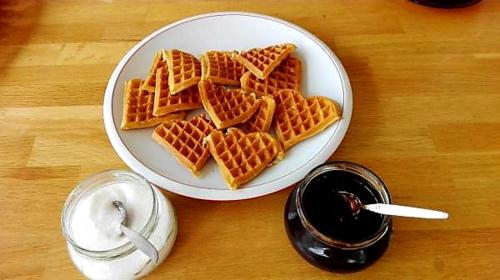 a plate of waffles on a table with a glass of soda at Flugumýri 2 in Varmahlid