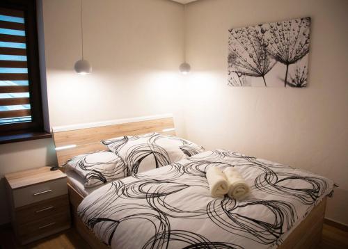 ein Schlafzimmer mit einem Bett mit einer weißen Schleife darauf in der Unterkunft Apartmánový dom Havranka - apartmán LAURA in Tale