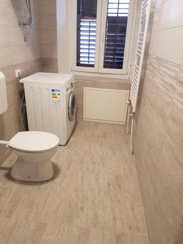 a bathroom with a toilet and a washing machine at Port in Izola