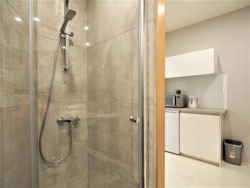 a shower with a glass door in a bathroom at VIP Apartamenty Stara Polana 2 in Zakopane