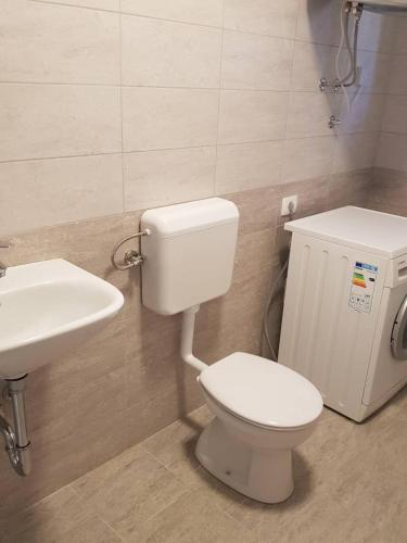 a bathroom with a white toilet and a sink at Port in Izola
