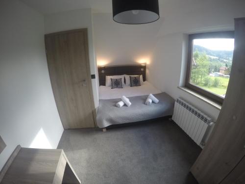 a bedroom with a bed with pillows and a window at Silver Residence in Rabka