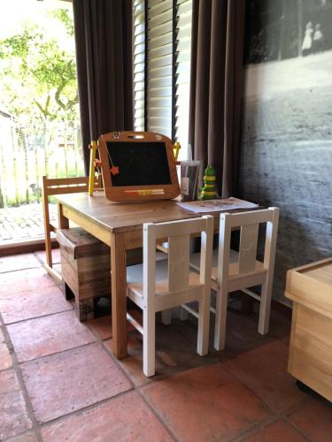 a laptop computer sitting on top of a wooden table at Hotel Hof van 's Gravenmoer in 's-Gravenmoer