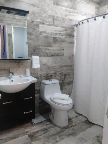 a bathroom with a toilet and a sink at Blue House Joyuda in Cabo Rojo