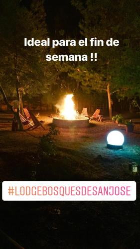 a fire pit in a park at night with the words local paraza ll fn at Bosques de San José Lodge in Algarrobo