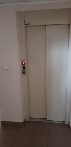 three white doors in a room with a wall at Apartment GEA 1 in Novi Sad