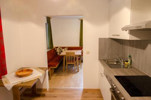 a kitchen and a living room with a table at Ferienwohnung Gertrud Dallavia in Unterleibnig
