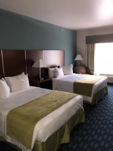 a hotel room with two beds and a window at Countryview Inn & Suites in Robinson
