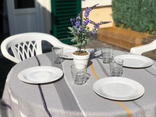 a table with plates and glasses and a potted plant on it at ABCdecor Italia in Imperia