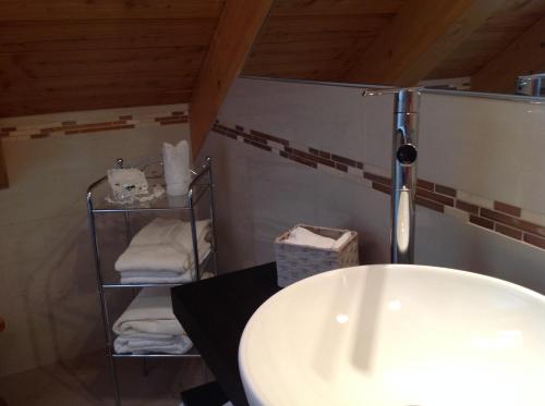 ein Badezimmer mit einem Waschbecken und einem Regal mit Handtüchern in der Unterkunft B&B Al Sasso in Toceno