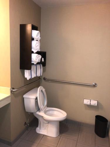 a bathroom with a toilet and towels on the wall at Countryview Inn & Suites in Robinson