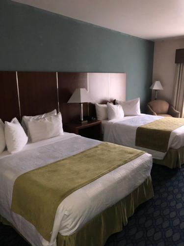 a hotel room with two beds and a chair at Countryview Inn & Suites in Robinson