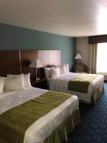 a hotel room with two beds and a window at Countryview Inn & Suites in Robinson