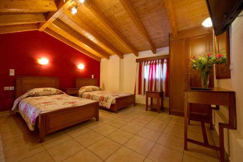 2 camas en una habitación con paredes rojas en Villa Diamond 2, en Parga